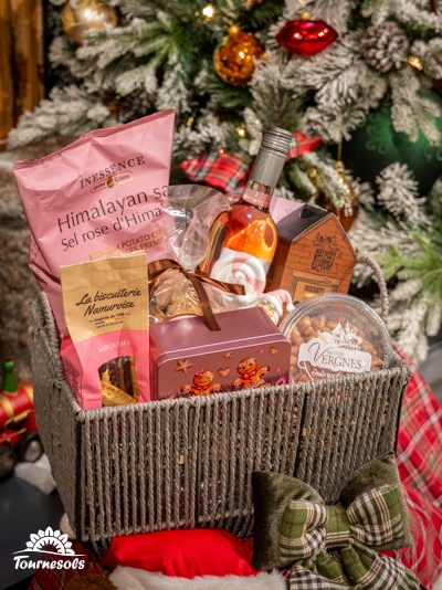 Panier garni Tournesols avec vins, chocolats et spécialités sous un sapin décoré.